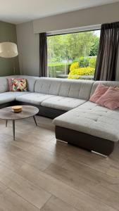 a living room with a couch and a table at Villa 't Zonneroosje in Nieuwpoort