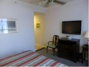a bedroom with a bed and a flat screen tv at Hilgard House Westwood Village in Los Angeles