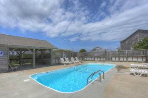 a large swimming pool with chairs at 7041 - Toes in the Sand in Whalebone