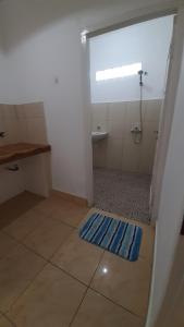 a bathroom with a shower and a blue rug on the floor at Tapada in Gili Islands