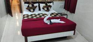 Un dormitorio con una cama con dos cisnes encima. en Hotel Metro Plaza Near BARC, en Bombay 13 fotos más