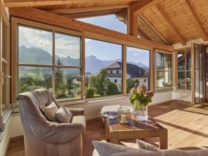 a living room with large windows and a table at Holiday apartment The Neuhaus in Abtenau