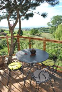 einen Tisch und Stühle auf einer Terrasse mit einem Baum in der Unterkunft L'Etournelle - Cabane Perchée in Chaussan