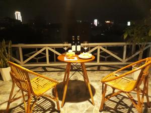 a table with two chairs and glasses of wine at Deluxe Private Room by Adora in Can Tho