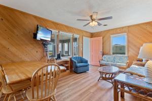 a living room with wooden walls and a ceiling fan at 7141 - Geri's Place #9 in Wanchese