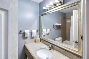 ein Badezimmer mit Waschbecken und Spiegel in der Unterkunft Rodeway Inn & Suites Port Arthur - Groves in Port Arthur + 45 Fotos