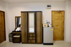 eine Küche mit einem Kühlschrank und einer Holztür in der Unterkunft 20 North Hotel Mae Sai in Ban Pa Muat