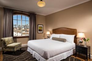 a bedroom with a bed and a chair and a window at Hotel Normandie Los Angeles in Los Angeles