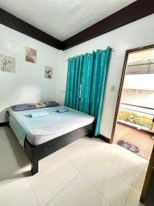 a bedroom with a bed and a window at Longay Homestay in General Luna