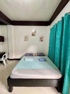 a bed in a room with green curtains at Longay Homestay in General Luna