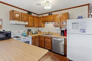 a kitchen with wooden cabinets and a white refrigerator at 5165 - Holden Inn in Croatan Shores