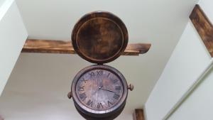 a clock hanging on a wall with a wooden cross at Machanents apartment in Vagharshapat