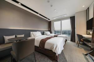 Una habitación de hotel con dos camas y un escritorio. en Kintex by K-tree, en Isan 152 fotos más