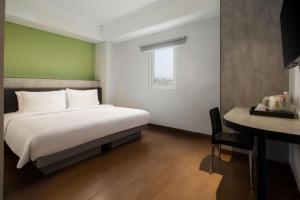 a bedroom with a bed and a desk with a desk at Amaris Hotel Pakuan Bogor in Bogor +149 photos