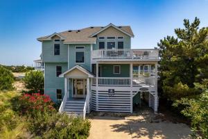a large blue house with a balcony on the beach at 1008 - Shellous in Corolla