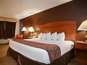 a hotel room with a large bed with white pillows at Best Western Manhattan Inn in Manhattan +127 photos