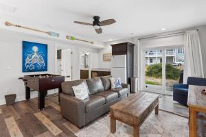 a living room with a couch and a pool table at 1013 - High Tides and Philly Forever in Corolla