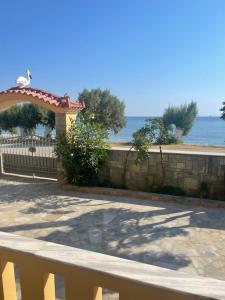 a bench sitting next to a stone wall and the ocean at beach mourteri Evia in Mourteri