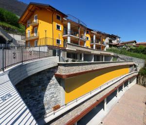 a bridge over a river with a yellow building at Residence Le Azalee & SPA in Vercana