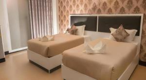 ein Schlafzimmer mit zwei Betten und einem Fenster in der Unterkunft The Premium Residence in Roi Et