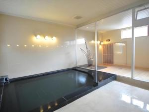 a swimming pool in a room with glass walls at Hotel Obokekyo Mannaka in Miyoshi