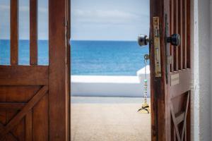 een open deur met uitzicht op de oceaan bij El Nido Seafront Hideaway by Bayside in Playa Honda