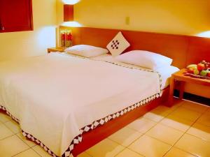 una camera da letto con un grande letto bianco e un tavolo di Nyiur Resort Hotel a Pangandaran