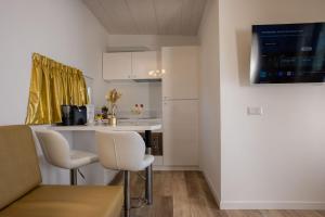 a kitchen with white chairs and a table and a counter at Miami Suite in Bellaria-Igea Marina