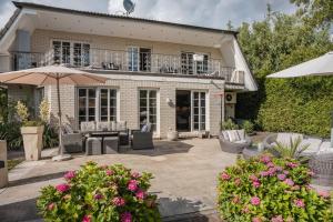 a house with a patio with chairs and an umbrella at Traumhaus Whirlpool Sauna Grill in Hamburg