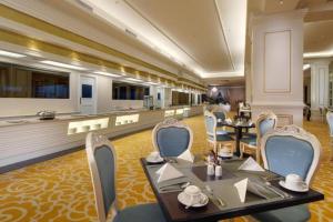 a restaurant with tables and chairs in a room at Adimulia Hotel Medan in Medan