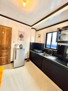 eine Küche mit einem Kühlschrank aus Edelstahl und einer Spüle in der Unterkunft RC- Longay Homestay in General Luna