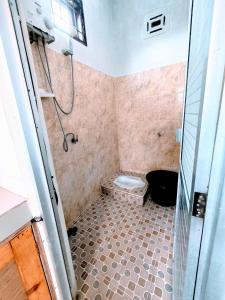 a bathroom with a shower and a toilet in it at Jirek Homestay Bukittinggi in Bukittinggi