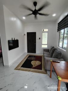 a living room with a couch and a ceiling fan at Supa Dupa Homestay Merbok 2 in Kampong Merbok