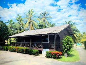 马兰Marang Guesthouse Resort的一座黑色的小建筑,有树木背景 更多16张照片