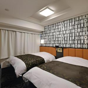 une chambre d'hôtel avec deux lits et une grande fenêtre dans l'établissement APA Hotel Tsukuba Bampaku Kinenkoen Ekimae, à Tsukuba