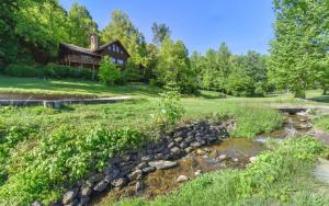 a creek in front of a log home at Pop A Bear in Pittman Center