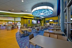 a dining area with tables and chairs in a restaurant at Disney's Art Of Animation Resort in Orlando