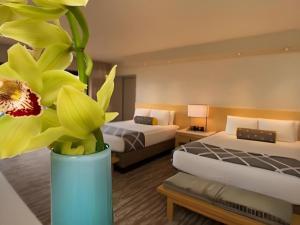 a hotel room with two beds and a vase with a flower at Disney's Contemporary Resort in Orlando +140 photos