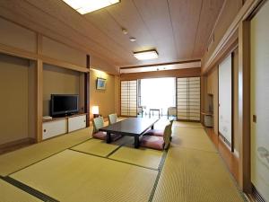 a dining room with a table and a television at Gifu Grand Hotel in Gifu