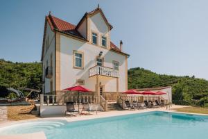a large house with a swimming pool in front of it at Palacete do Guerreiro SPA & Country House in Oliveira do Hospital