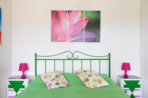 a bedroom with a green bed with two lamps at Casa di Osio in Siena
