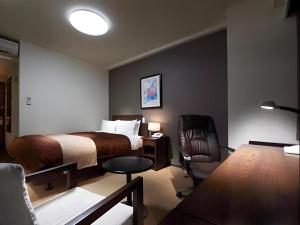 a hotel room with a bed and a chair at Hotel Sealuck Pal Utsunomiya in Hanawadamachi