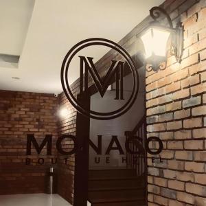 a sign on a brick wall with a sign on it at Monaco Boutique Hotel Sadong Jaya in Kota Kinabalu