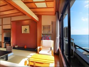 a living room with a view of the ocean at Tsukino Sumika Atami Juraku Hotel in Atami