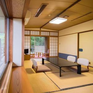 una stanza con tavolo da ping pong e sedie di Yufuin Onsen Yufuin Nanairo no Kaze a Yufu