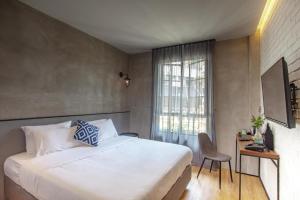 a bedroom with a bed and a desk and a window at Atelier Hotel Johor Bahru in Johor Bahru +144 photos