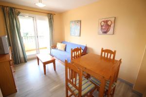 a living room with a table and a blue couch at Toda una EXPERIENCIA en la COSTA DEL SOL, a 100m de la Playa in Algarrobo-Costa