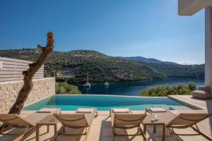une piscine avec des chaises et une vue sur l'eau dans l'établissement Villa Oliva -Seaside Charm with Village at Your Doorstep, à Sývota