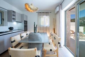une cuisine et une salle à manger avec une table et des chaises dans l'établissement Villa Oliva -Seaside Charm with Village at Your Doorstep, à Sývota