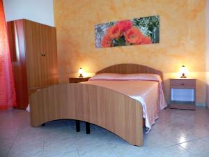 トッレ・サン・ジョヴァンニ・ウジェントにあるVilletta Saraのベッドルーム1室(ベッド1台、ランプ付きテーブル2台付)
